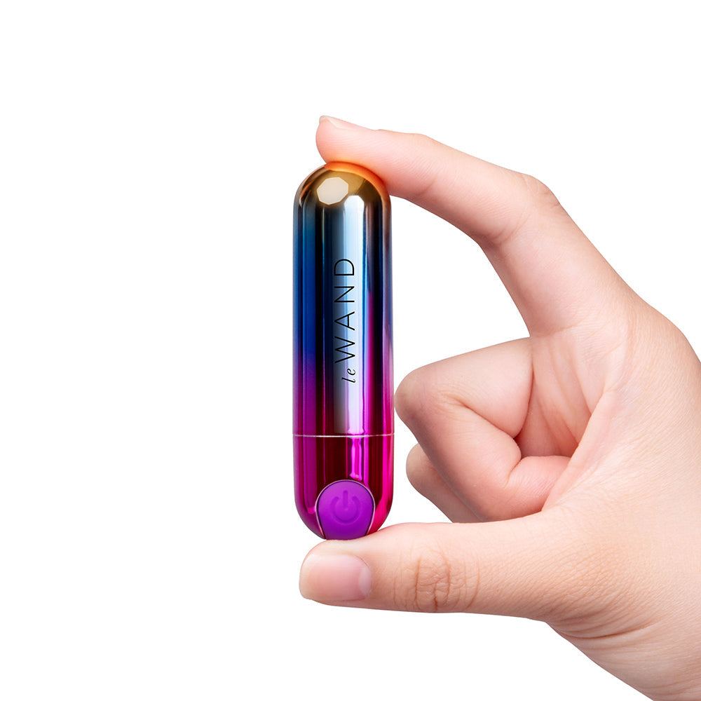 Le Wand Essentials Rechargeable Rainbow Bullet Vibrator held in hand, showcasing its sleek design and vibrant colors.