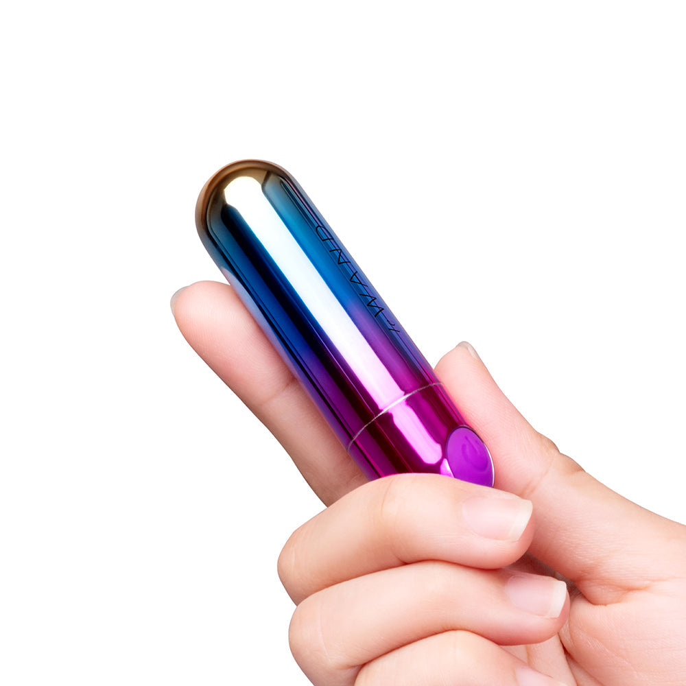 Le Wand Essentials Rechargeable Rainbow Bullet Vibrator held in hand, showcasing sleek design and vibrant colors.