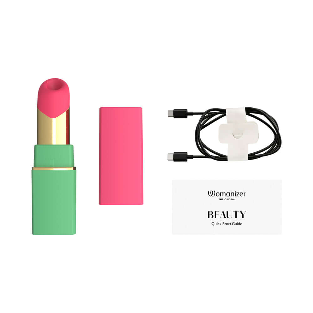 Womanizer Beauty Clitoral Stimulator Green Pink with charging cable and quick start guide.