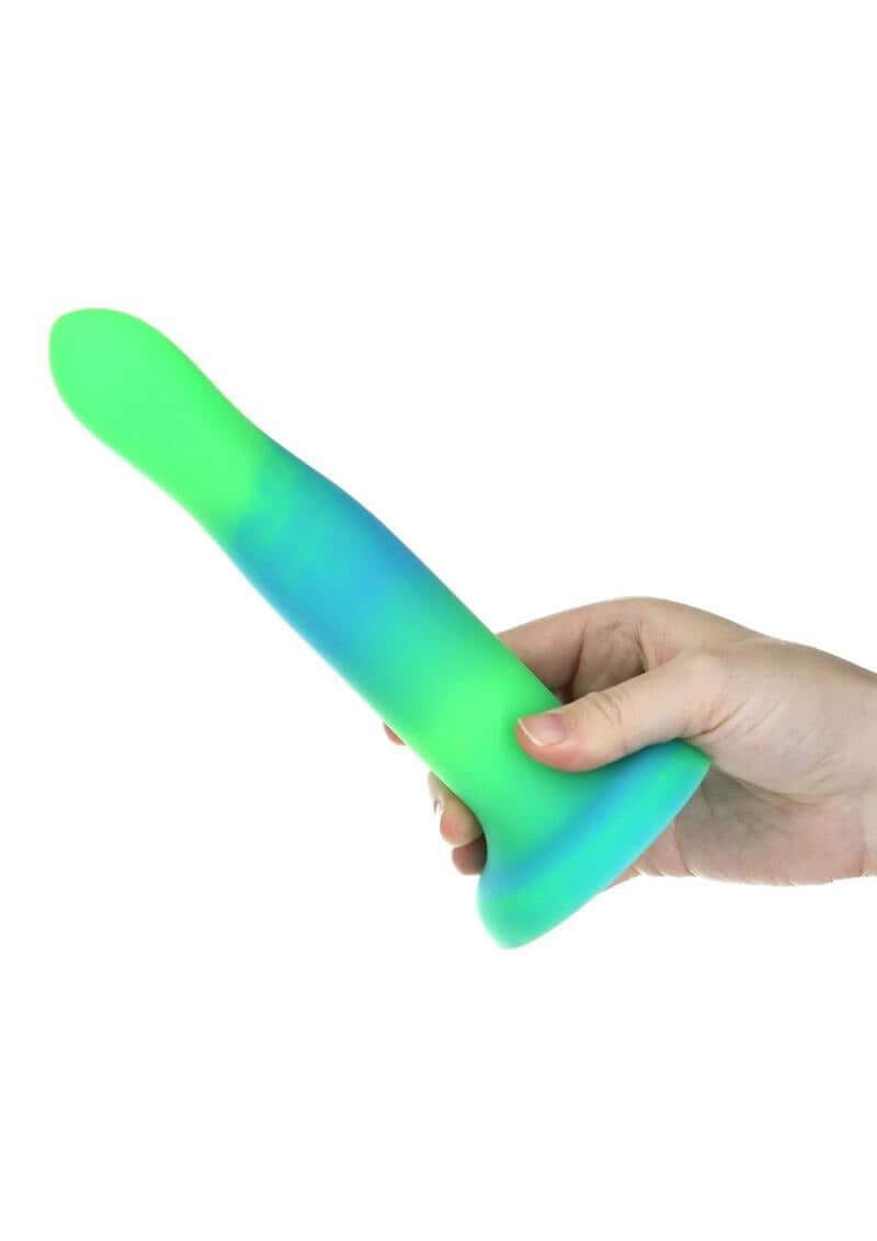 Addiction Rave Silicone Glow In The Dark Dildo 8 inch Blue Green held in hand, showcasing the vibrant colors.