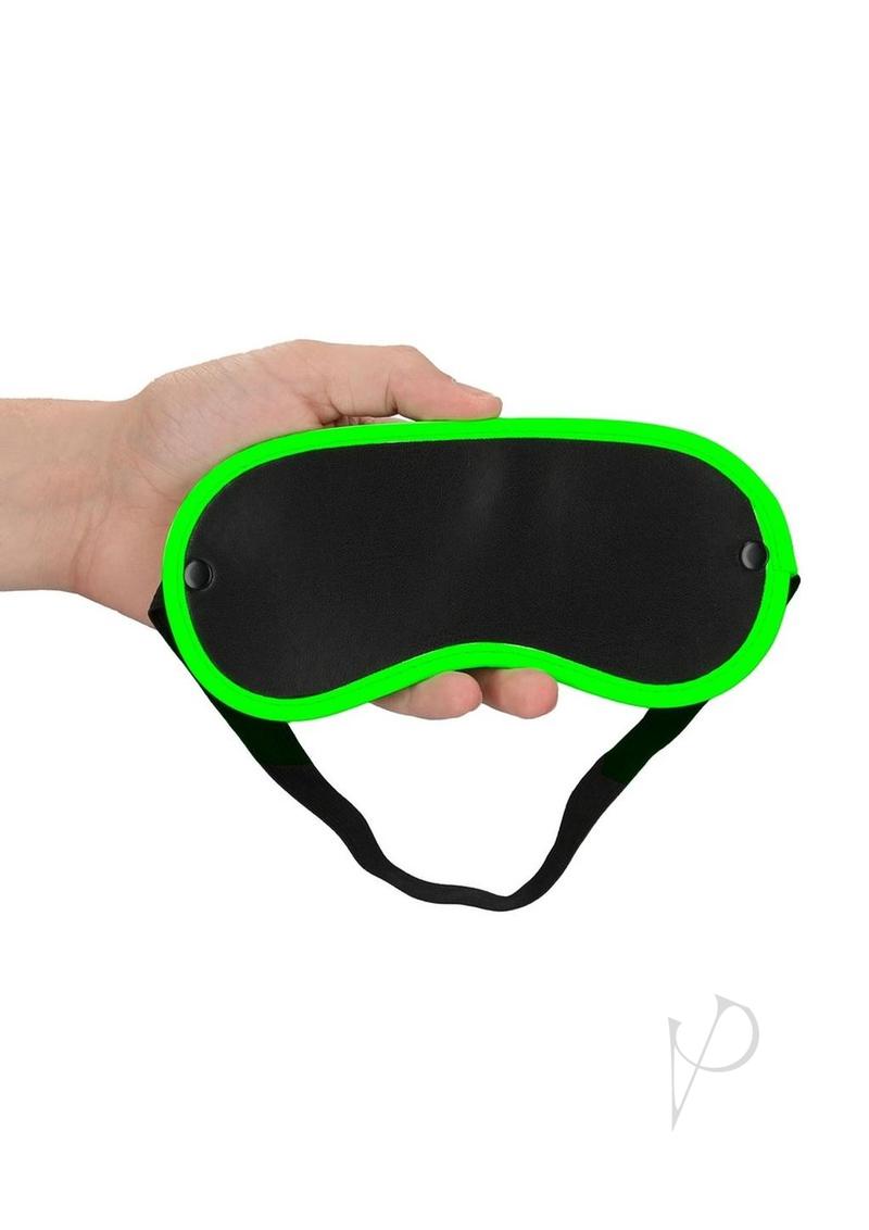 Ouch Eye Mask Glow in the Dark Green held in hand with bright green detailing on edge.