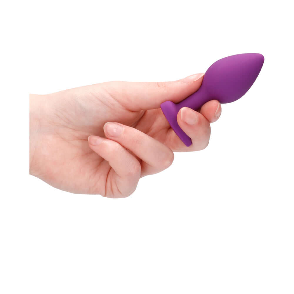 Flexible Silicone Diamond Heart Butt Plug Purple Regular held in a hand, showcasing its smooth design and body-safe material.