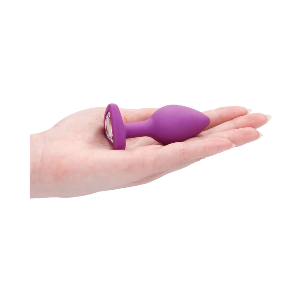 Flexible Silicone Diamond Heart Butt Plug Purple Regular held in a hand, showcasing its elegant design and comfortable size.