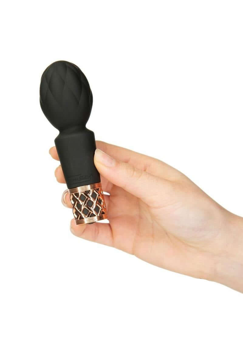 Pillow Talk Secrets Pleasure Rechargeable Wand Gold held in hand showcasing sleek design and elegant details.