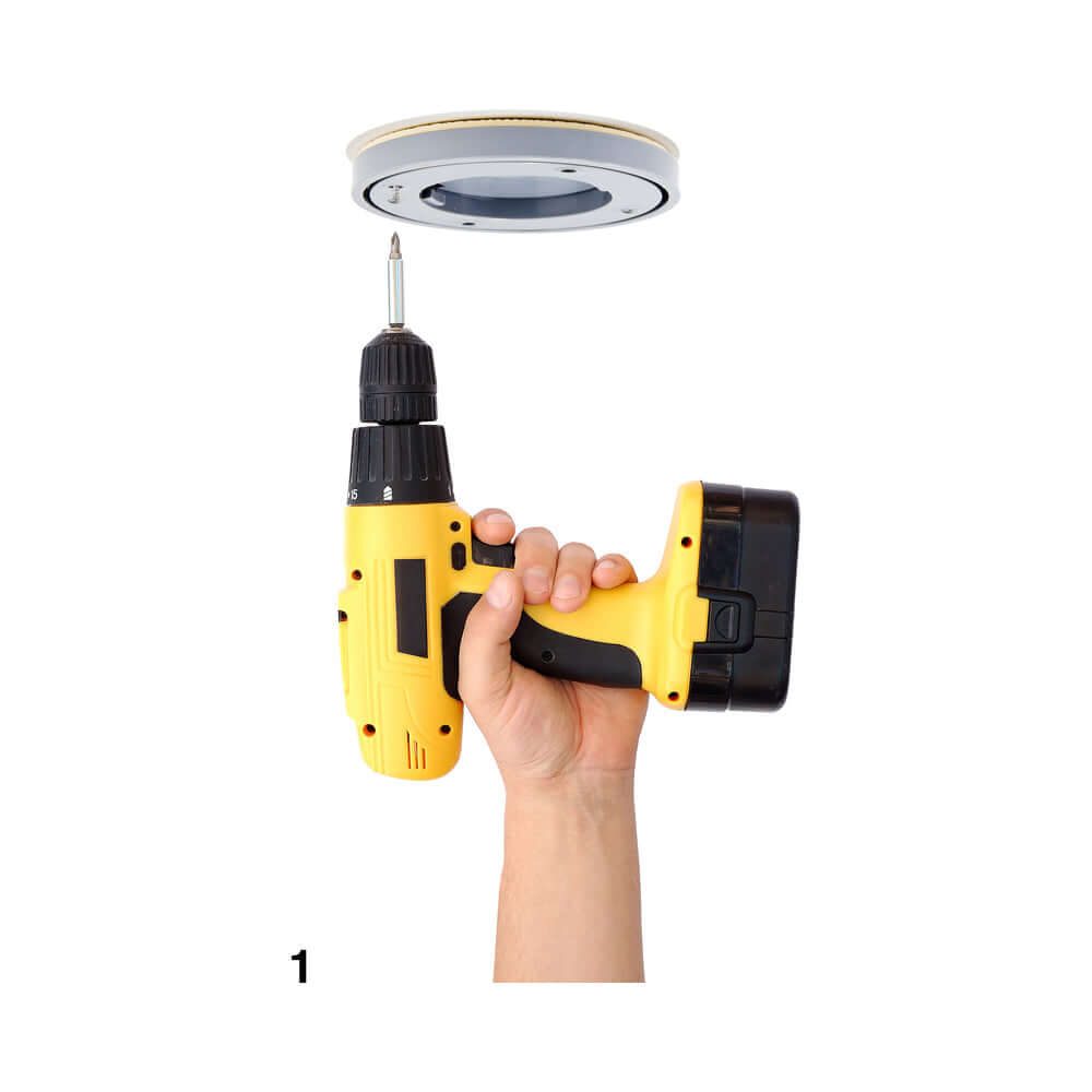 Ouch Fully Adjustable Dance Pole Silver installation process with a yellow drill in hand, ready to secure the pole.