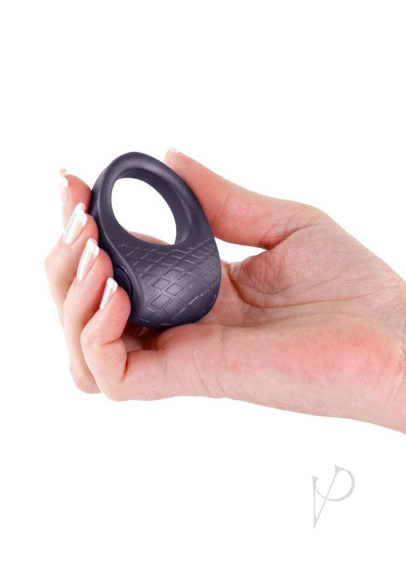 Hand holding the Seduction Levi Rechargeable Silicone Cock Ring Gray, showcasing its sleek design and texture.
