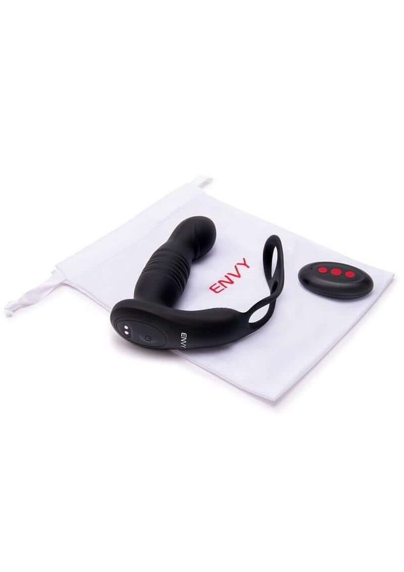 Envy Thruster P-Spot Vibrator & Ring with Remote Control lying next to its remote and storage pouch.