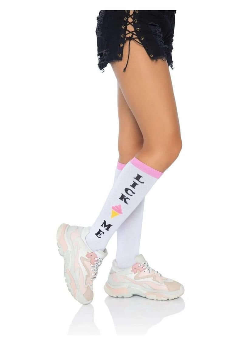 Model wearing Leg Avenue Lick Me Knee Socks OS with playful design, styled with casual shorts and sneakers.