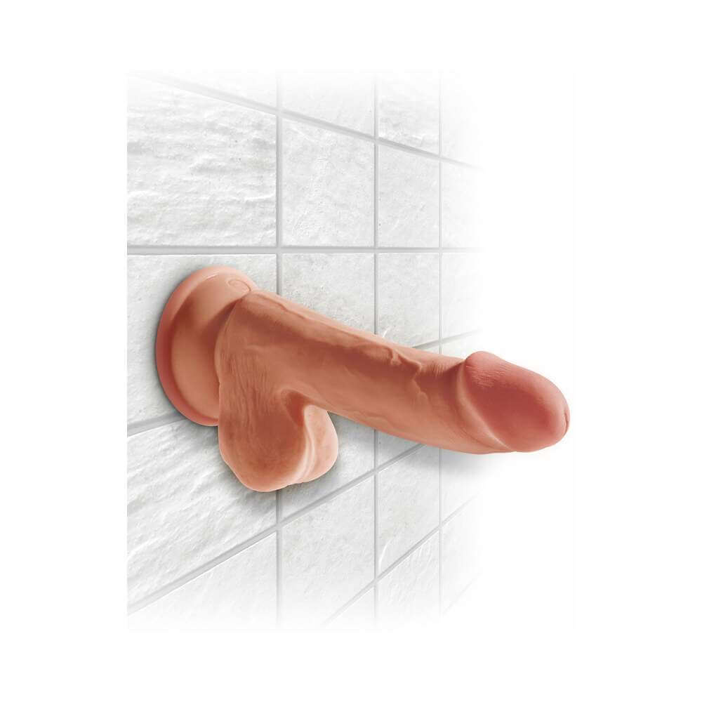 King Cock Plus 6.5 inch Triple Density Cock With Balls Tan mounted on a tiled wall with strong suction cup.