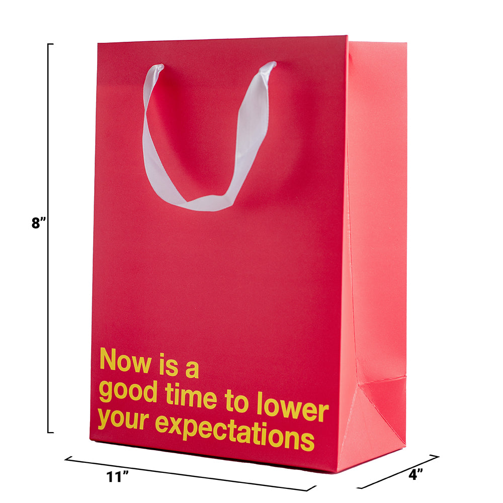Lower Your Expectations Color Gift Bag Red with humorous message on a bright red background.