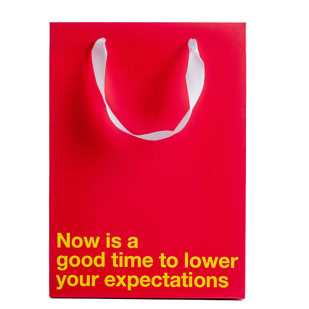 Lower Your Expectations Color Gift Bag Red featuring bold message on red background.