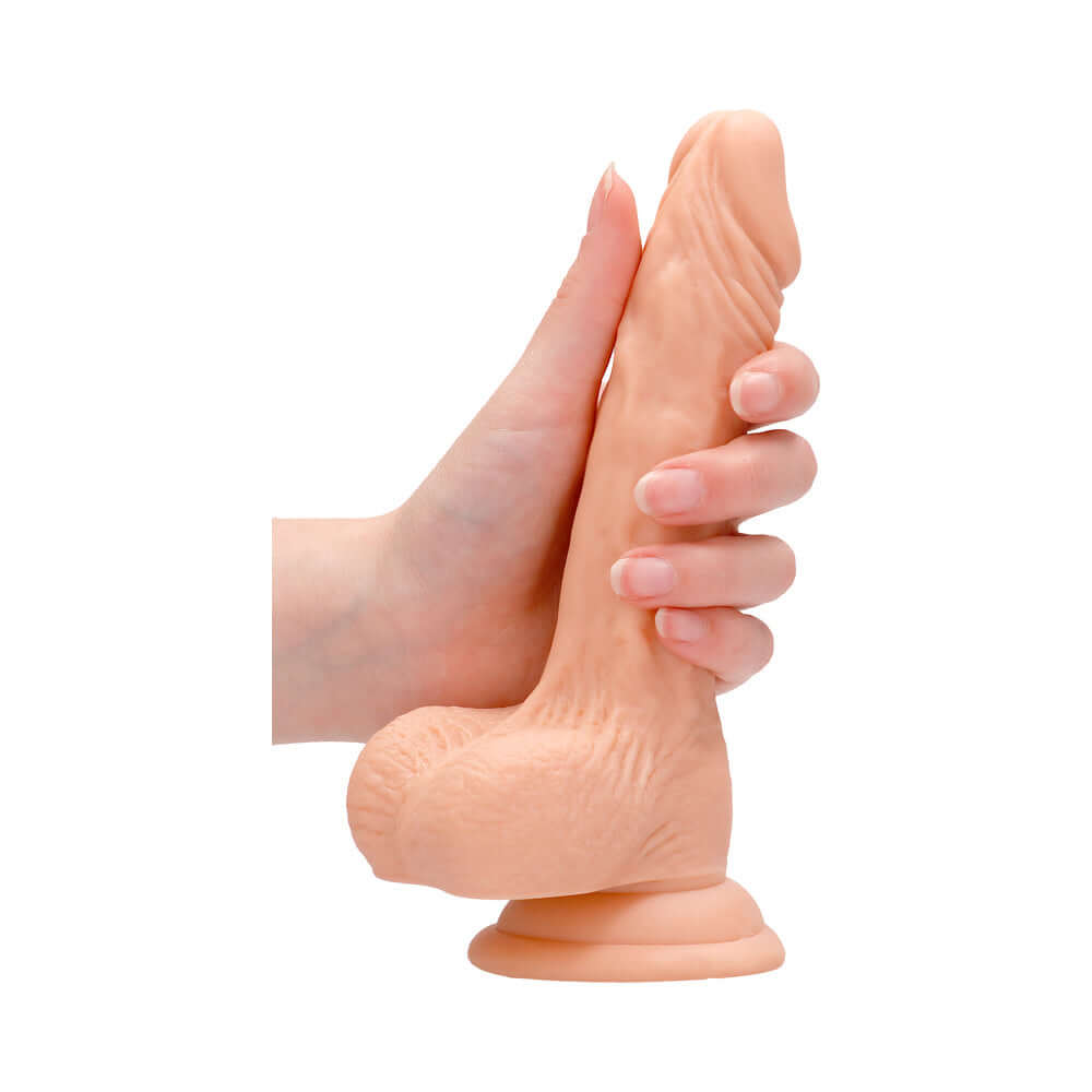 RealRock Realistic 7 inch Dildo With Balls & Suction Cup Beige being held in hand.