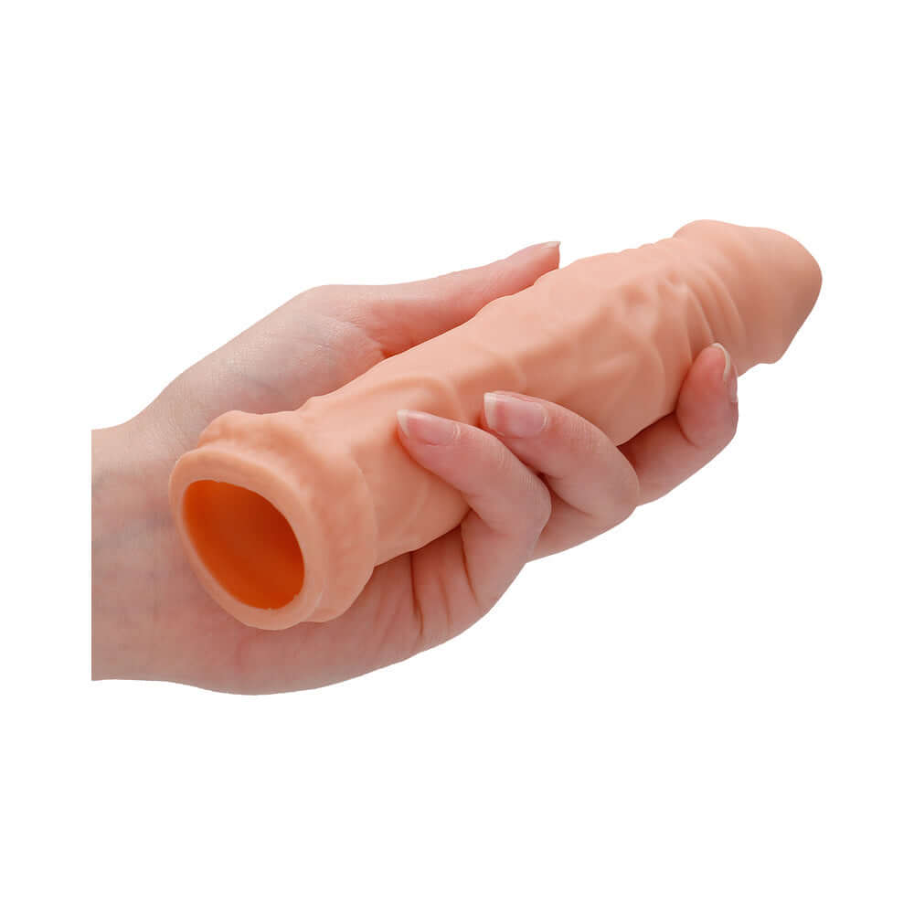 RealRock Realistic 6 inches Penis Sleeve Extender Beige held in hand showcasing its realistic design and texture.