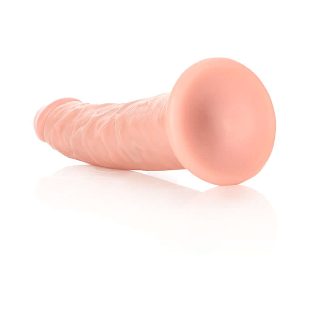 RealRock Realistic 6 inches Slim Dildo With Suction Cup Beige viewed from the side on a reflective surface.