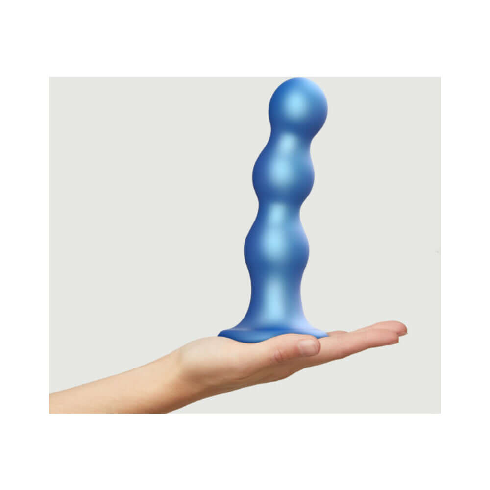 Strap-on-me Hybrid Silicone Dildo Plug Balls Metallic Blue X-large in hand, showcasing its unique curves and design.