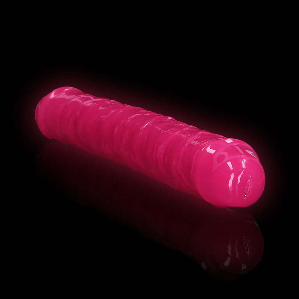 RealRock Glow in the Dark Double Dong 12 inch Neon Pink on a black background, showcasing its vibrant glow and smooth design.