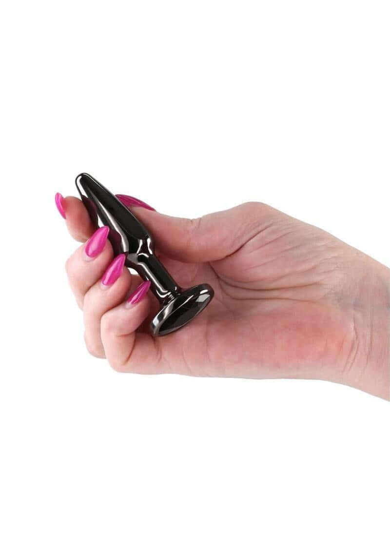Rear Assets Chrome Tapered Anal Plug Small Gray held in a hand with pink nails, showcasing its sleek chrome design.