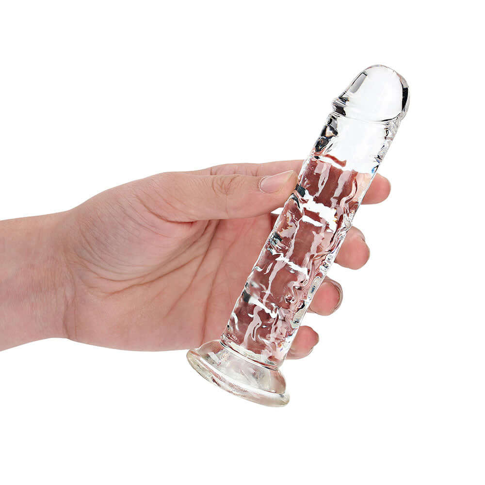 RealRock Crystal Clear Straight 6 inches Dildo Without Balls Clear held in hand for demonstration.
