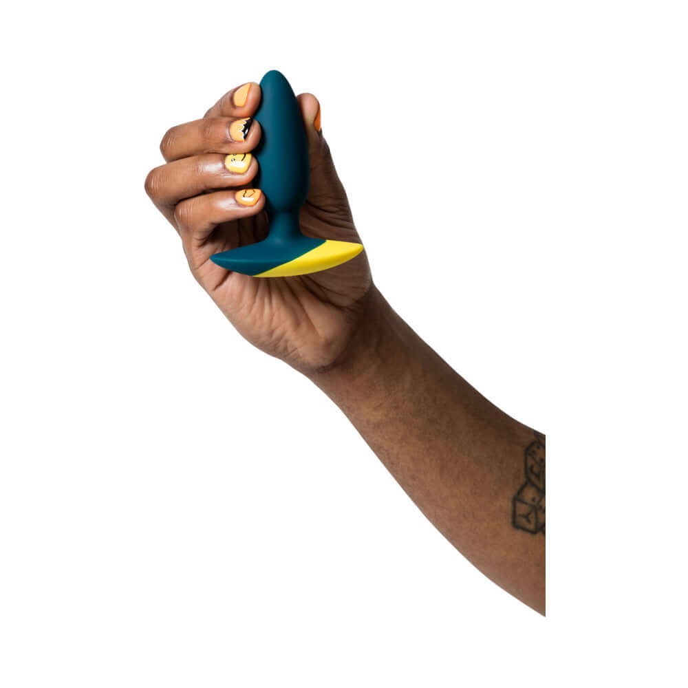 Person holding ROMP Bass Rechargeable Silicone Vibrating Anal Plug Dark Green with a vibrant design.