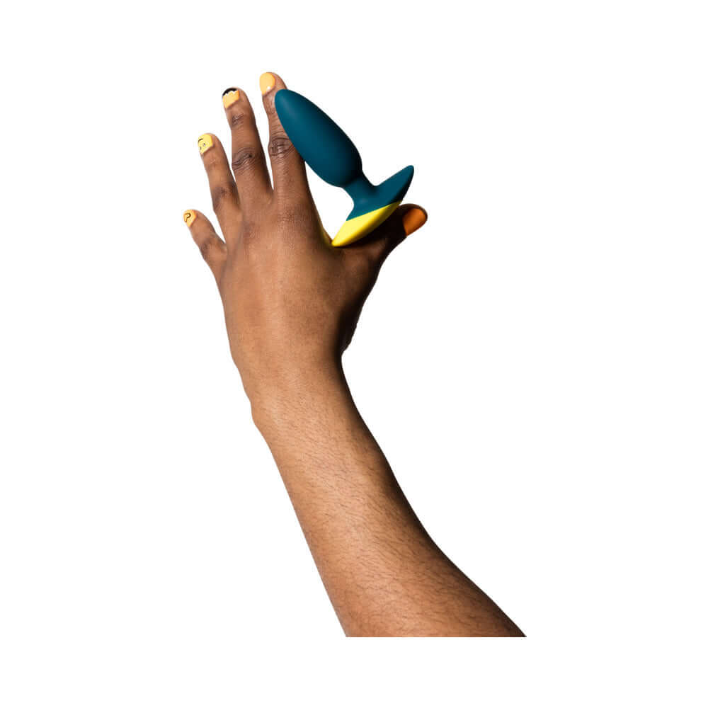 Hand holding the ROMP Bass Rechargeable Silicone Vibrating Anal Plug Dark Green for demonstration.