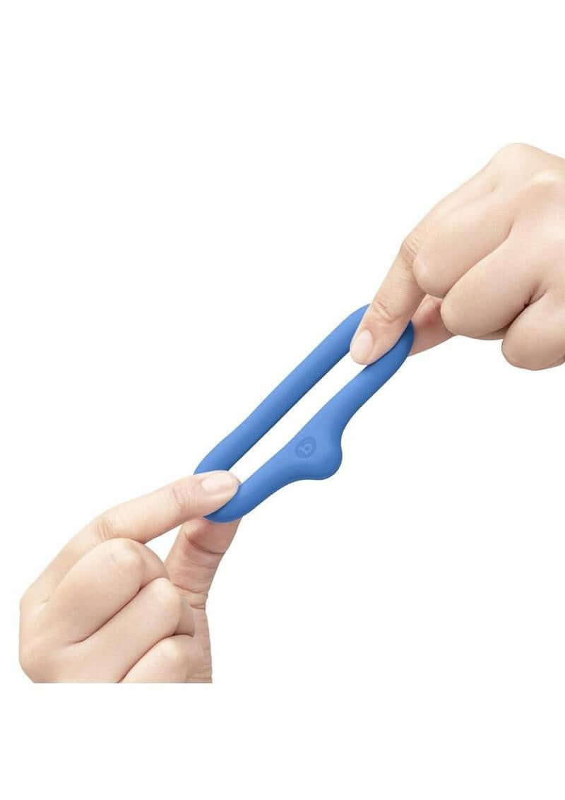 B-Vibe Flex Ring Drip Silicone Cock Ring Blue held between two fingers, showcasing its design and flexibility.