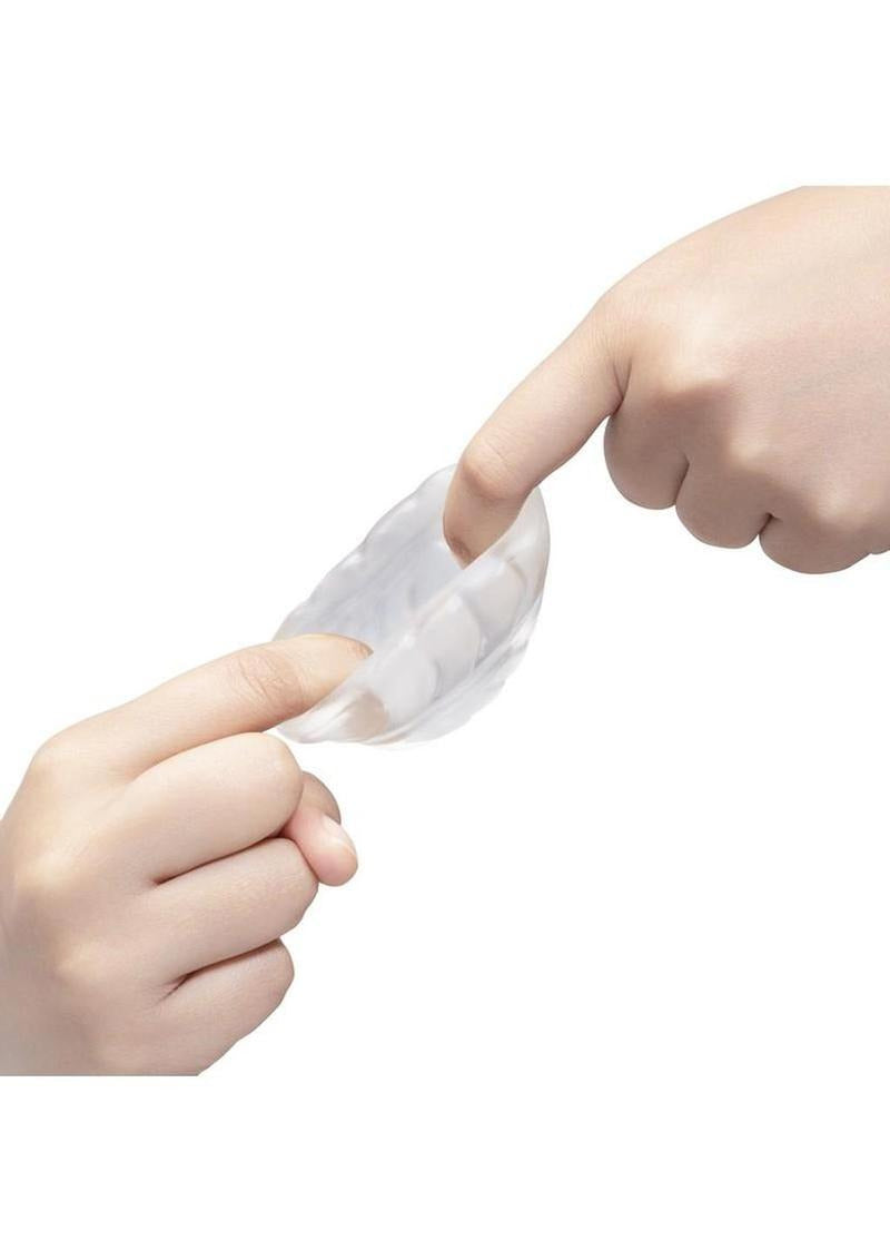 B-Vibe Stretch Tech Barrel Ultra Stretchy Cock Ring Clear being stretched by two hands, showcasing its flexibility and comfort.