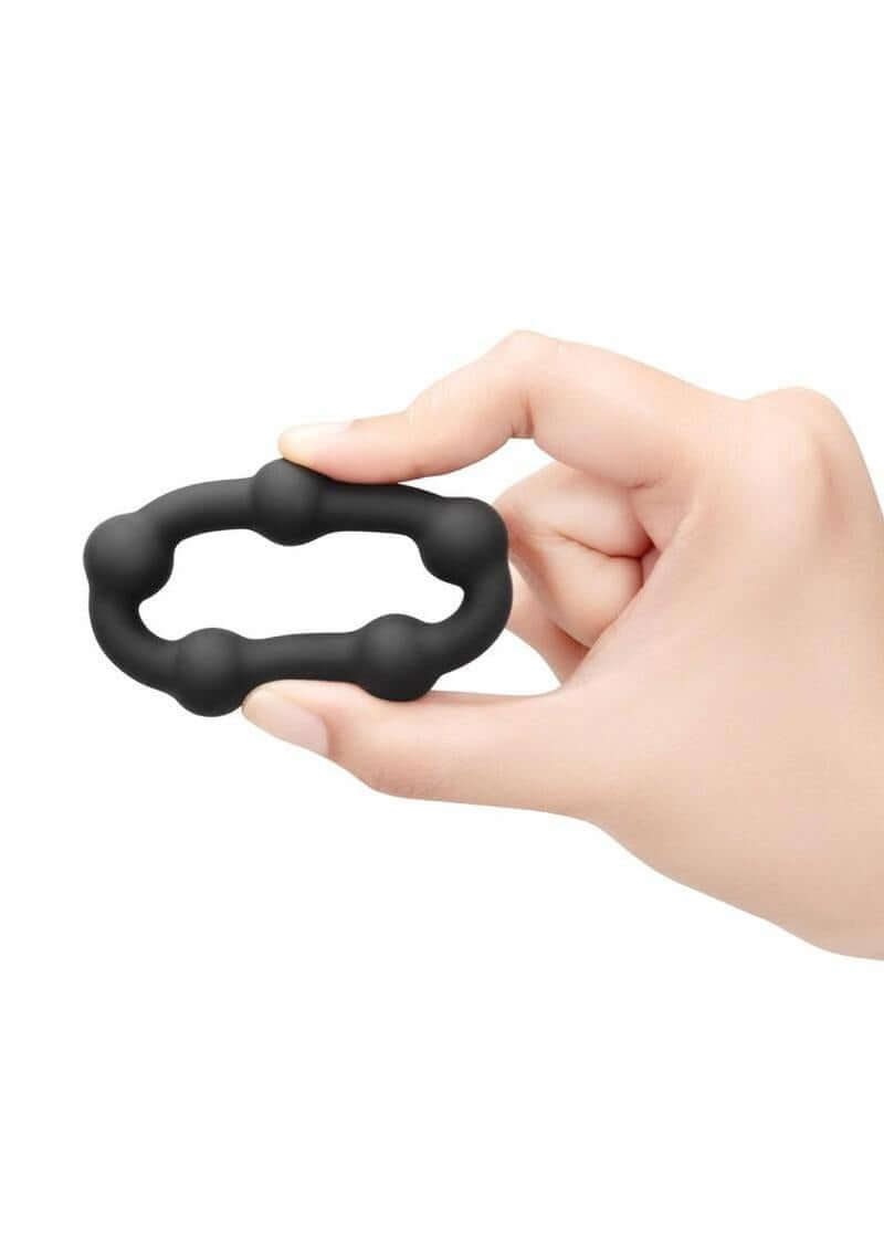 B-Vibe Snug Ring Orbit Nubby Silicone Cock Ring Black held in hand showcasing its design and comfort.