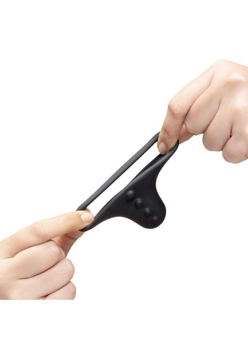 B-Vibe Flex Ring Shaft Silicone Cock Ring & Ball Stretcher Black being stretched by hands, showing its flexibility and comfort.