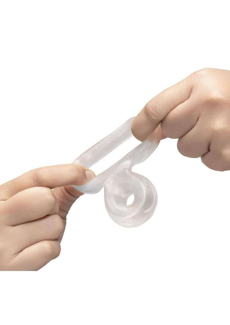 B-Vibe Stretch Tech Double Barrel Ultra Stretchy Cock Ring Clear being stretched between two hands.