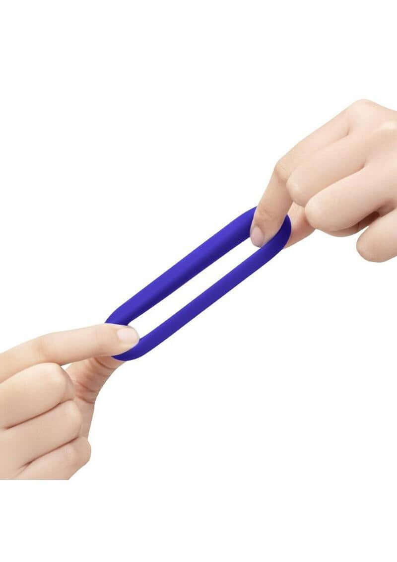 B-Vibe Flex Ring GT Silicone Cock Ring 32 mm Blue being stretched between two hands.