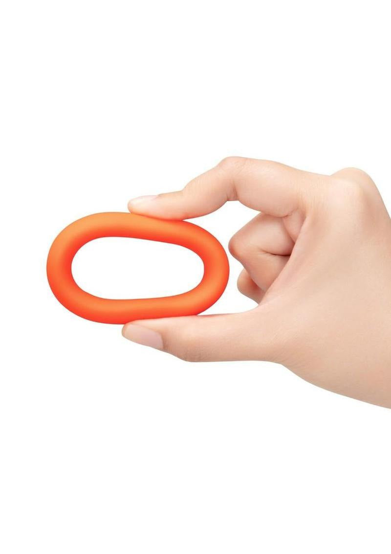 B-Vibe Snug Ring Silicone Cock Ring 40 mm Orange being held in a hand, showcasing its comfortable, durable design.
