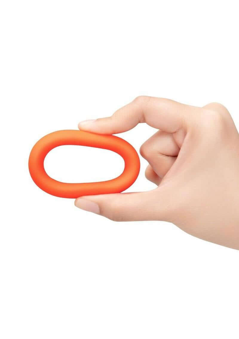 B-Vibe Snug Ring Silicone Cock Ring 40 mm Orange being held in a hand, showcasing its comfortable, durable design.