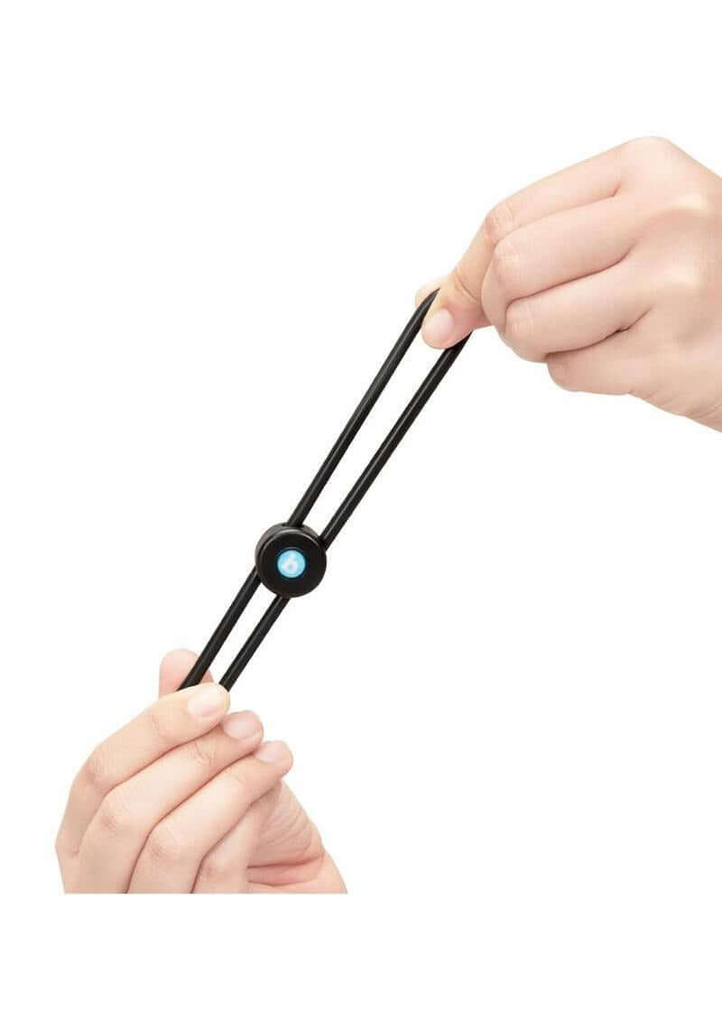 B-Vibe Lasso Grip Adjustable Silicone Cock Ring Black being held to showcase its flexible design and ergonomic grip.