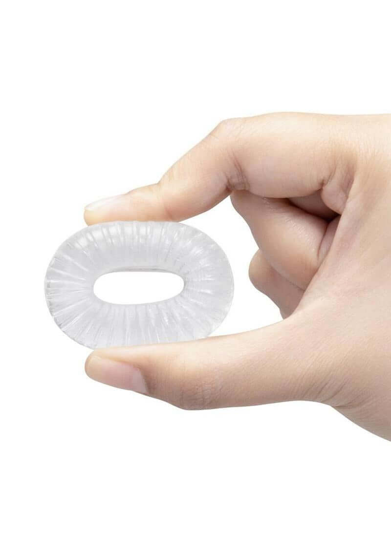 Hand holding B-Vibe Stretch Tech Swirl Ultra Stretchy Cock Ring Clear, showcasing its flexible design.