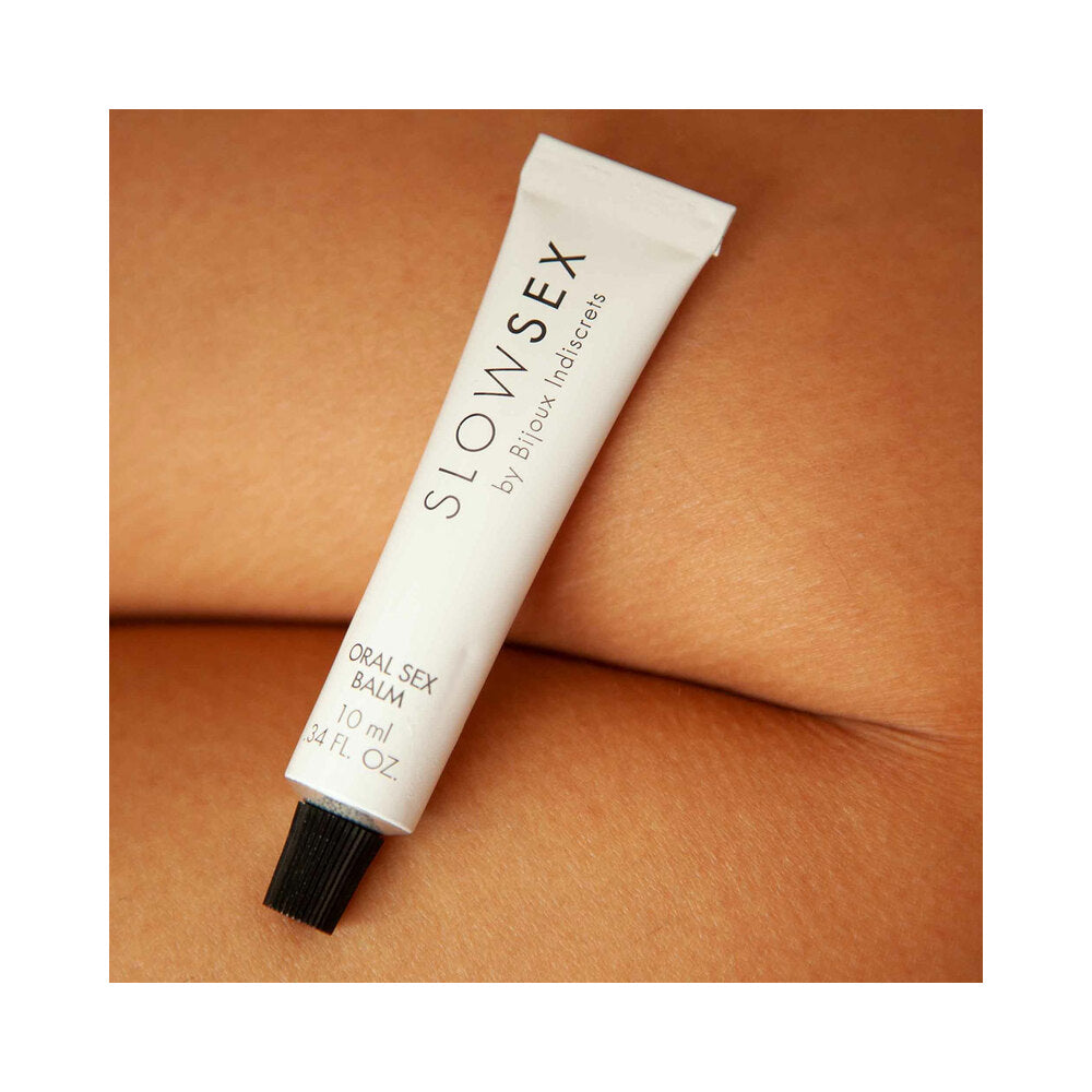 Bijoux Indiscrets Slow Sex Oral Sex Balm 0.34 Oz tube resting on skin, emphasizing sensual pleasure.