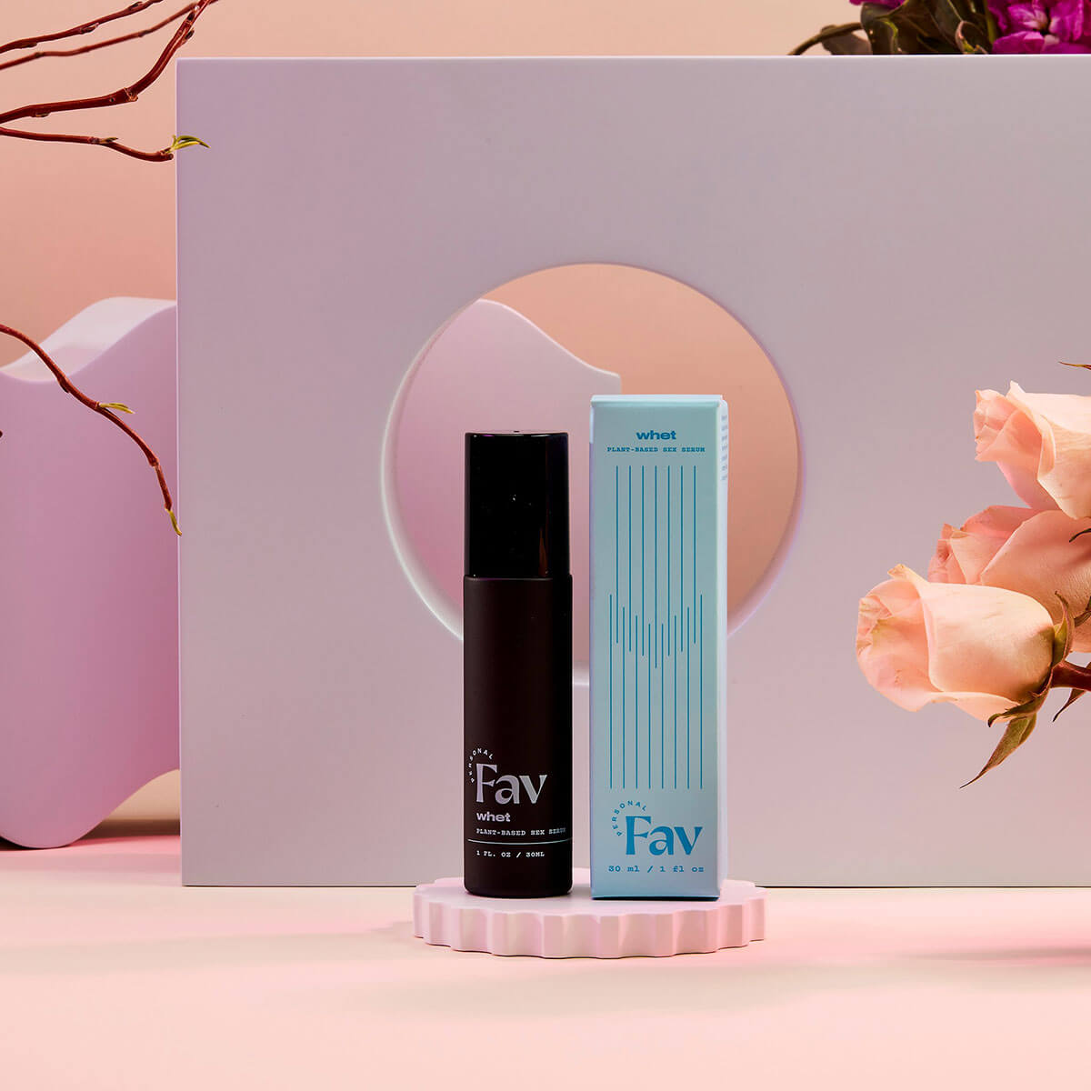 Personal Fav Whet Plant Based Sex Serum 1 Oz displayed elegantly with floral accents on a stylish pedestal.