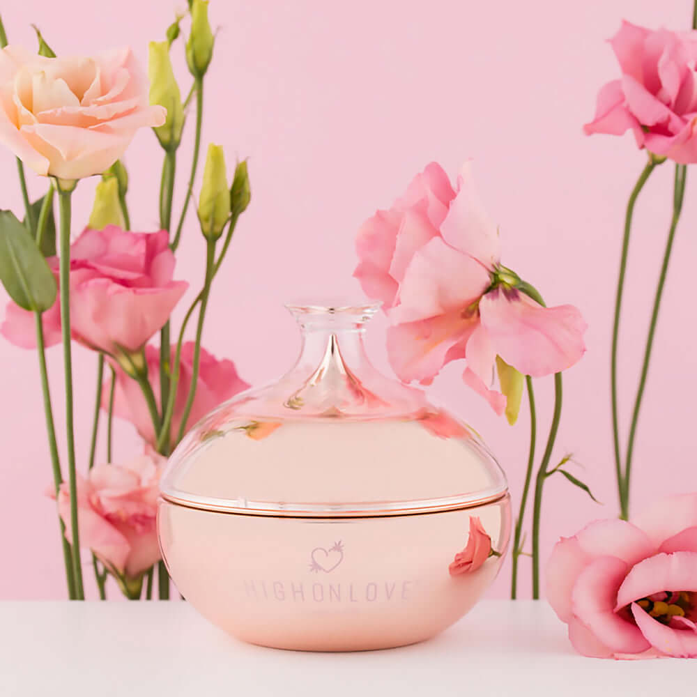 HighOnLove Canna Body Butter in an elegant jar surrounded by pink roses on a pastel background.