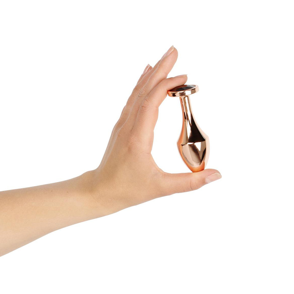 Hand holding Rosy Gold Nouveau Butt Plug, showcasing its luxurious design and shiny aluminum finish.