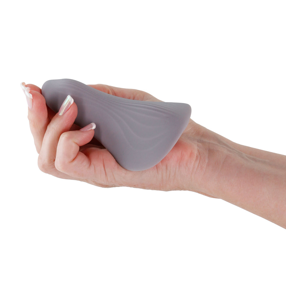 Desire Mantra Rechargeable Silicone Panty Vibe Gray being held in hand demonstrating its flexible design.