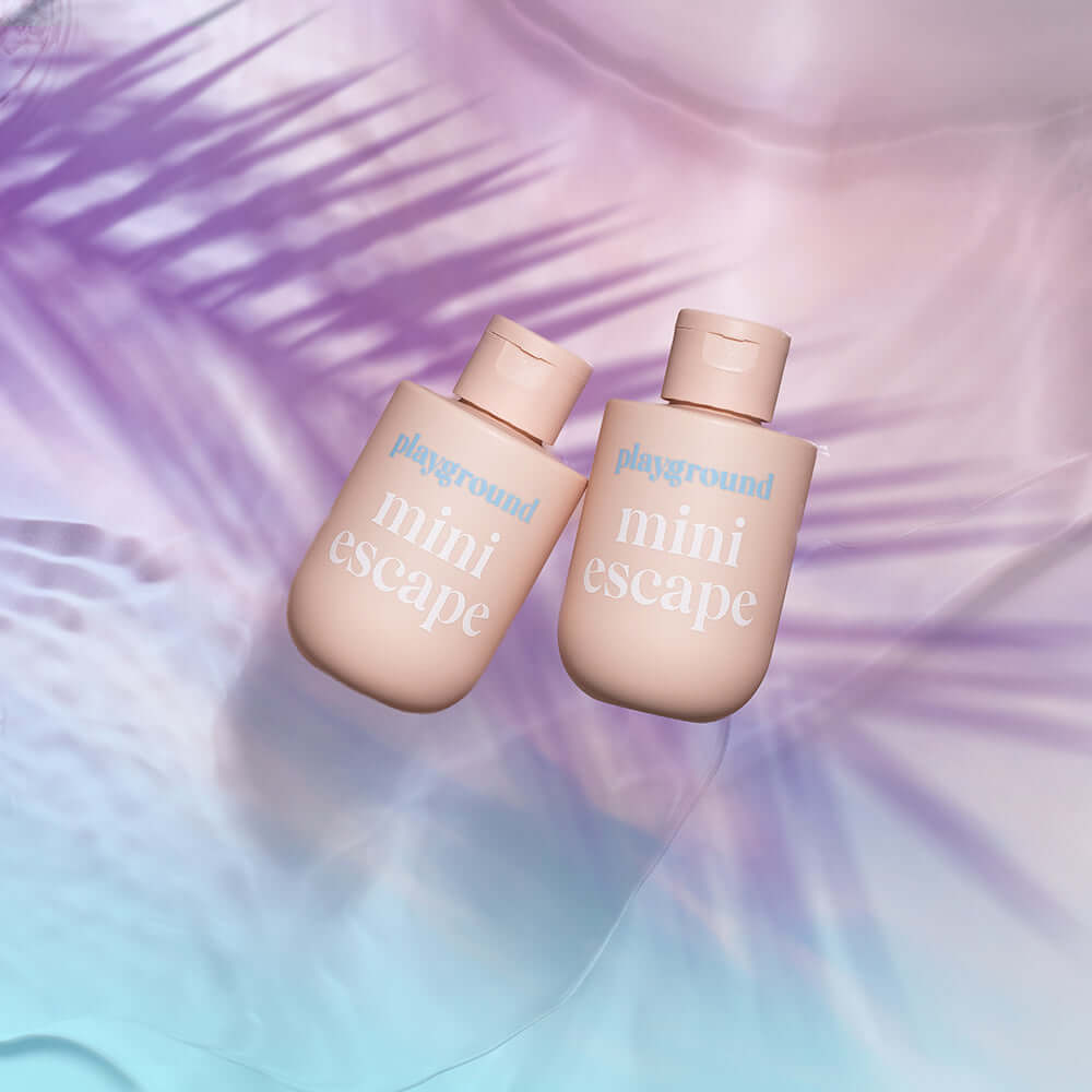 Playground Mini Escape Water-Based Personal Lubricant 3.7 Oz bottles on a colorful background.
