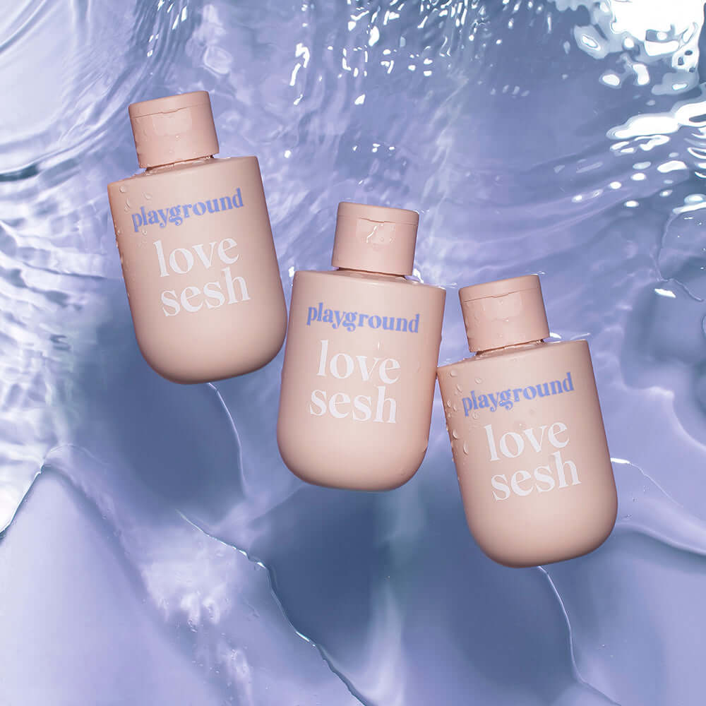 Playground Love Sesh Water-Based Personal Lubricant 3.7 Oz bottles floating in water, showcasing smooth design.
