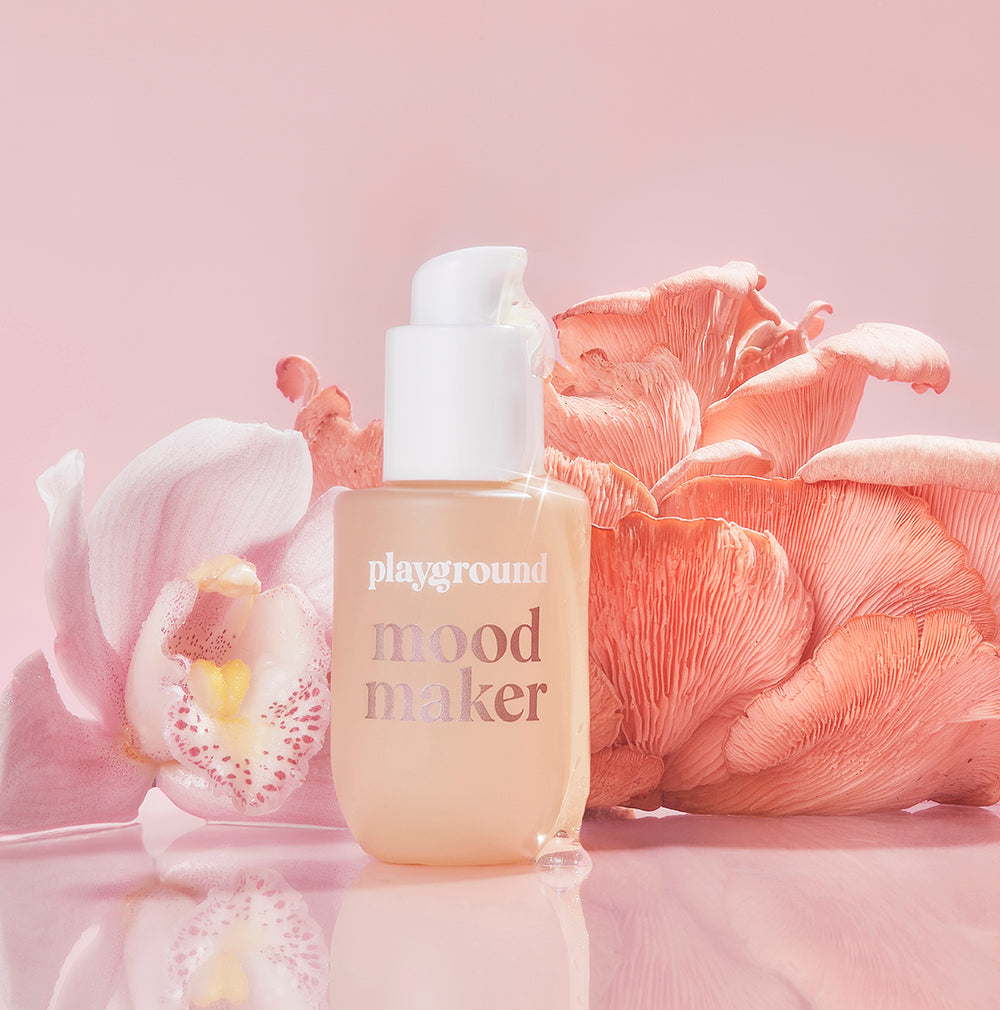 Playground Mood Maker Intimacy Oil 30 ml bottle with pink petals in the background, showcasing sensual oil for enhanced intimacy.