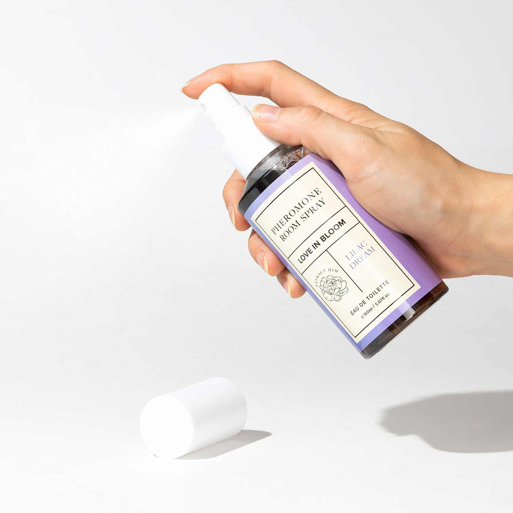 Eye of Love Bloom Attract Him Pheromone Room Spray Lilac Dream 5 Oz being sprayed from a hand.