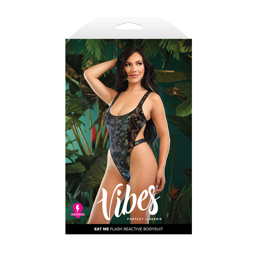 Fantasy Lingerie Vibes Eat Me Flash Reactive Bodysuit M L displayed on packaging with model in tropical setting.