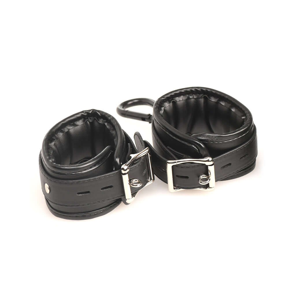 Soft leather wrist restraints with adjustable buckles for BDSM play.