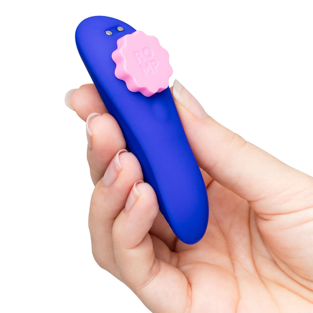 ROMP Party Wearable Panty Vibrator Purple held in hand, featuring a sleek design and pink control button.
