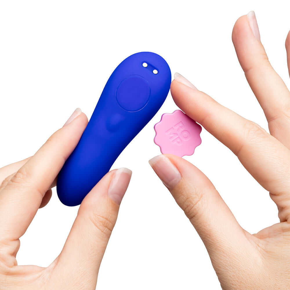 ROMP Party Wearable Panty Vibrator Purple in hand, showcasing its body-safe silicone design and remote control feature.