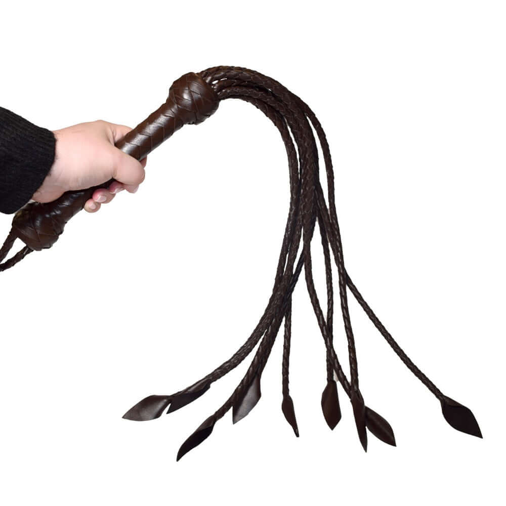 Prowler RED Leather Flogger Brown held in hand, showcasing its durable leather and flexible tails for BDSM play.