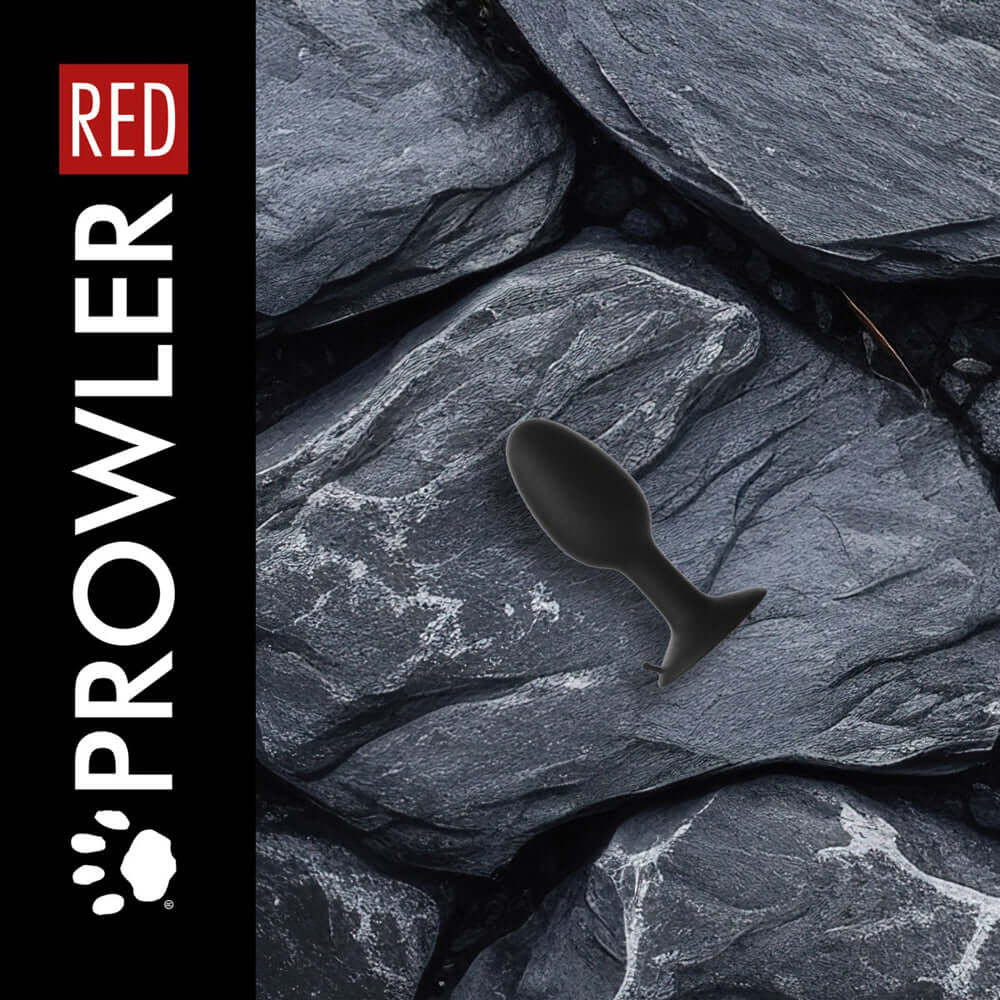 Prowler RED Weighted Butt Plug Black Small on textured grey stones for comfortable stimulation.