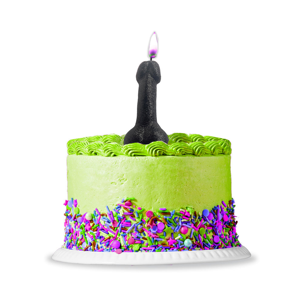 A fun cake topped with a Black Glitter Penis Candle amidst colorful sprinkles and green frosting.